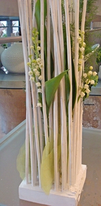 composition de muguet. Cette création est le coup de cœur de murielle-bailet.com! Travaillée dans un esprit nature très déco, Tempo est une composition qui habillera avec beaucoup de charme votre intérieur. Le blanc immaculé du muguet  crée une atmosphère de douceur printanière. Voici une création à se procurer sans hésiter!
